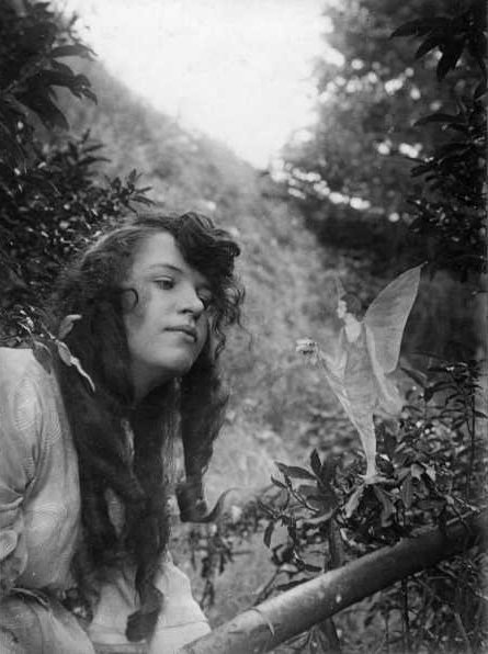 Figure 4 - The fourth photograph of the Cottingley fairies, Fairy Offering Posy of Harebells to Elsie, 1920.  From the Wikicommons and in the public domain in the US.